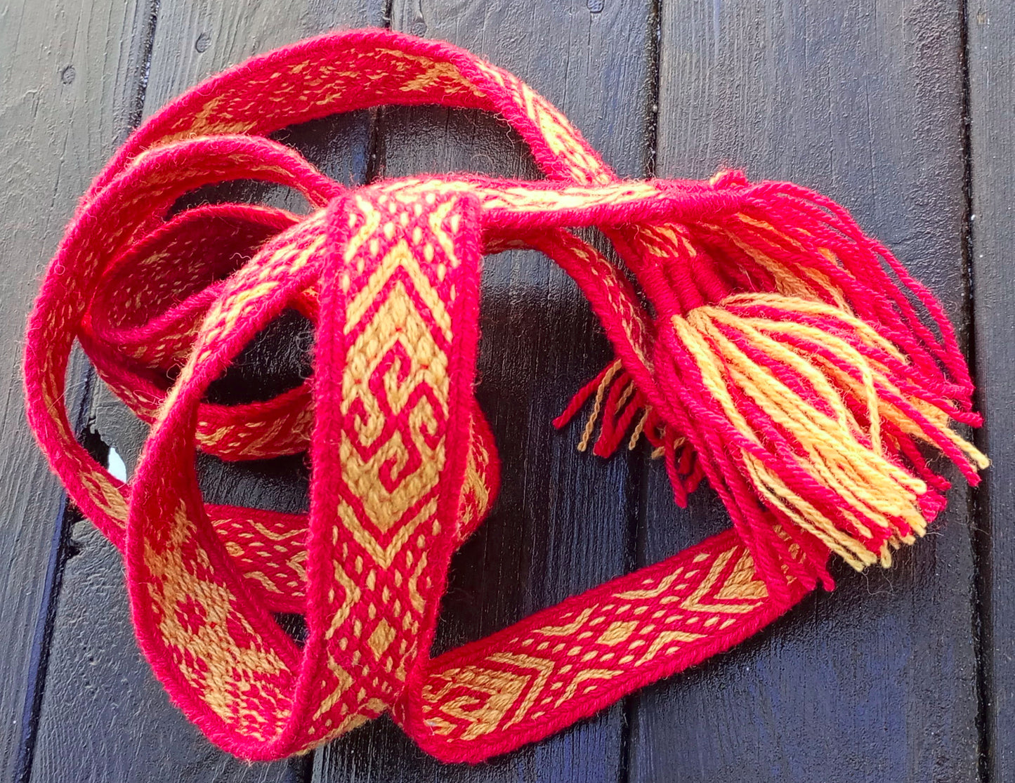 Red and yellow tablet woven belt with curly suncross motive